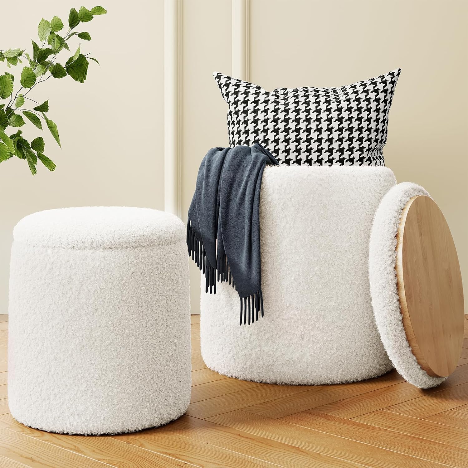 a white round stool with a black and white pillow and blanket